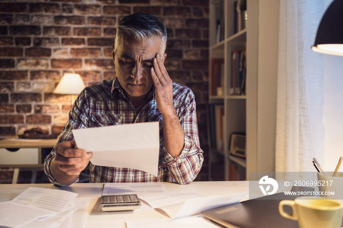 Worried man checking his domestic bills at home