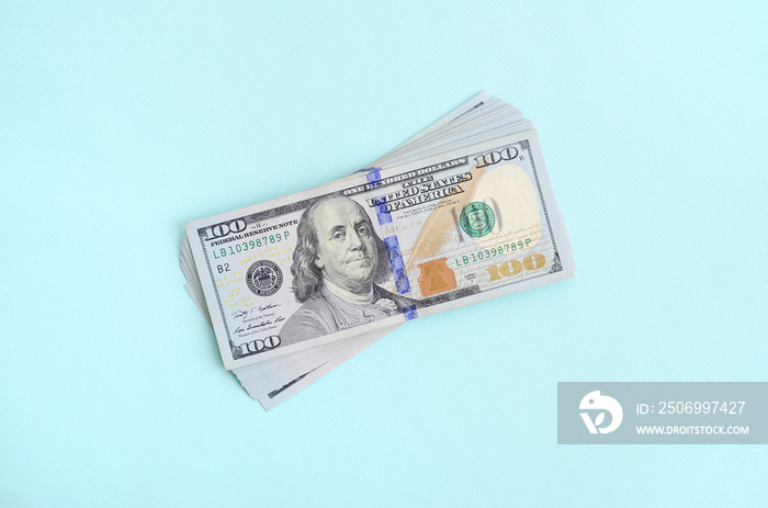 中间有蓝色条纹的新设计美元钞票位于淡蓝色背景上