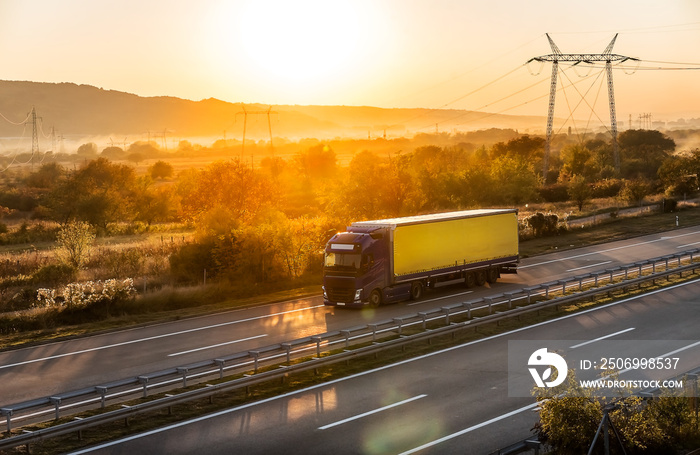 Transportation truck passing along highway in a dreamy sunset. Highway transportation with setting s