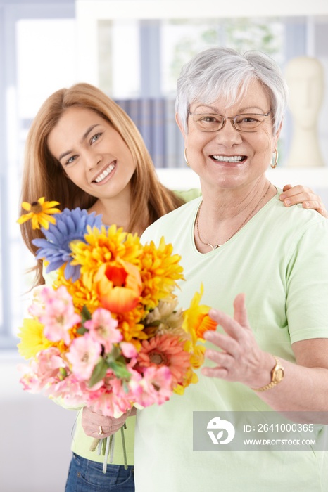 Happy senior mother with flowers at mothers day