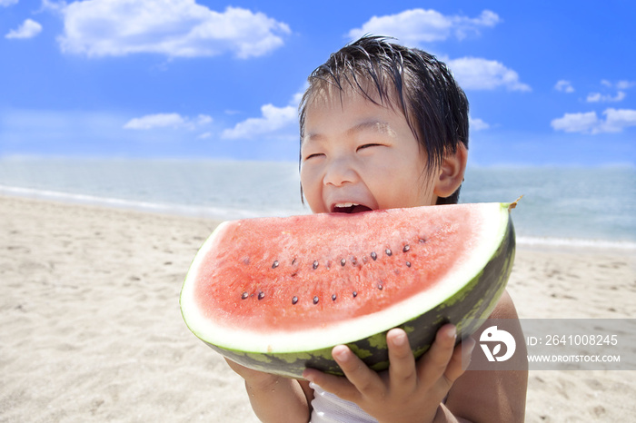 在夏天的海里吃西瓜的孩子