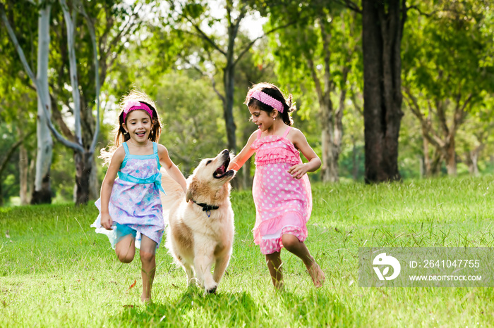 两个小女孩带着金毛猎犬跑步