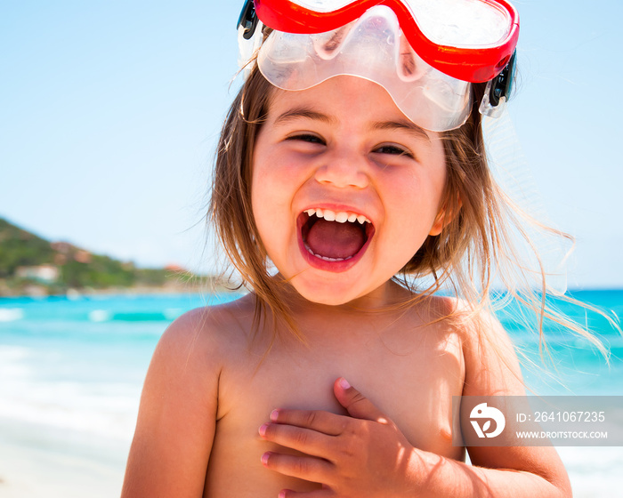 Bambina al mare con maschera che ride