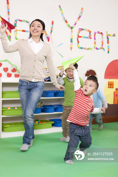 幼儿园小朋友和老师玩纸飞机