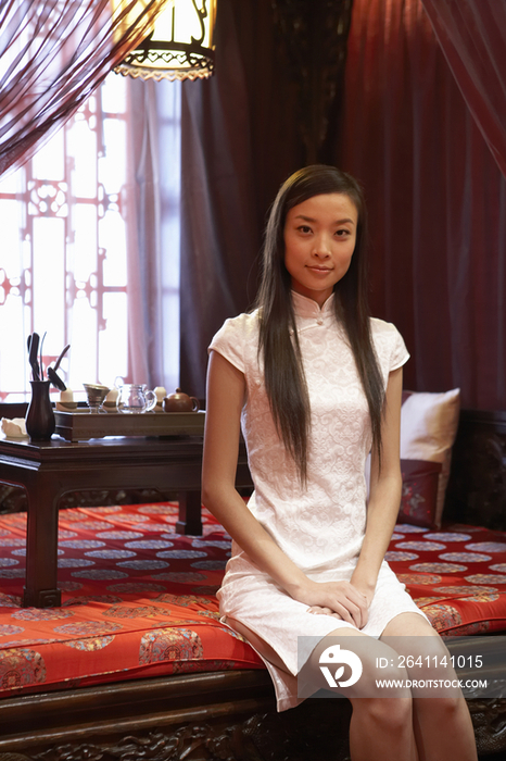 穿旗袍的年轻女子坐在茶室中