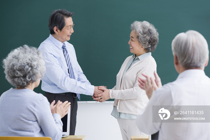 老年人在课堂和老师握手