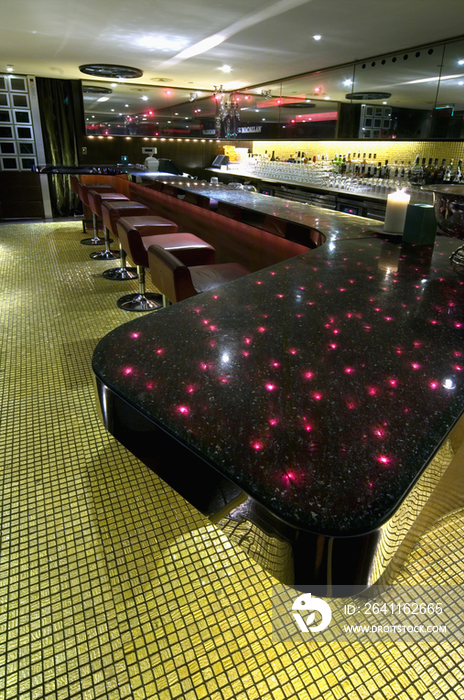 Reflection of red lights on bar counter in restaurant