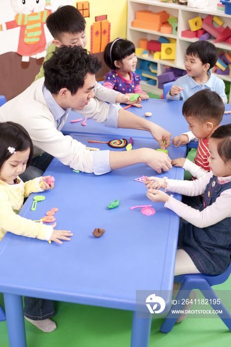 幼儿园老师教孩子们捏橡皮泥