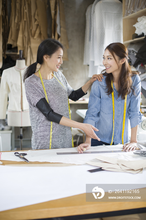 两个女服装设计师在工作室谈论