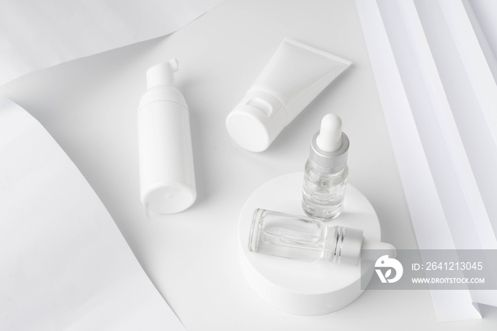 Beauty natural skincare product mock up. Serum glass vials on white circle podium with lotion bottle