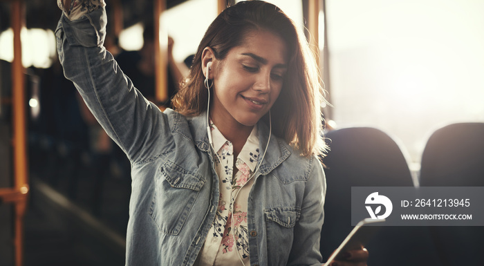 Young woman riding on a bus listening to music