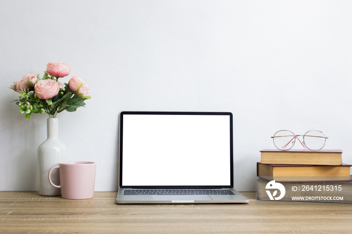 Mock up computer with books and coffee mug and roses over the light background. 