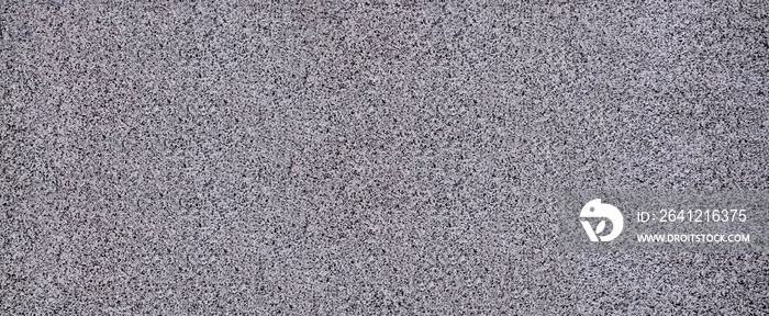 The texture of solid granite tiles. Hard and slippery gray granite surface with a relief discharge w