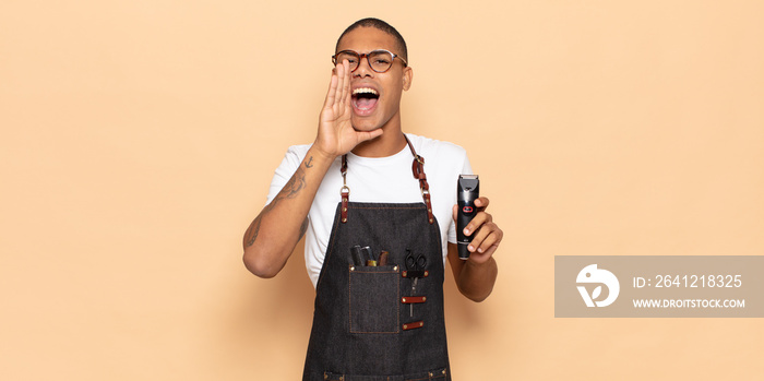 young black man feeling happy, excited and positive, giving a big shout out with hands next to mouth