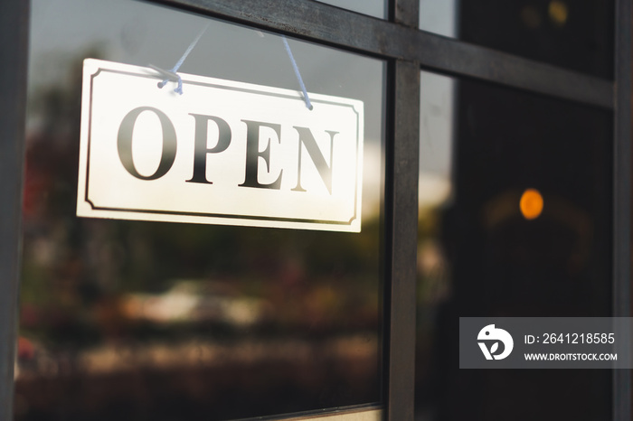 A business sign that says ‘Open’ on cafe or restaurant hang on door at entrance. Vintage color tone 