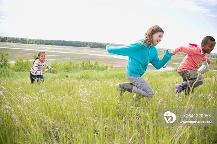 elementary aged children running in grassland