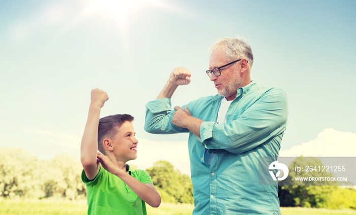 family, generation, power and people concept - happy grandfather and grandson showing muscles