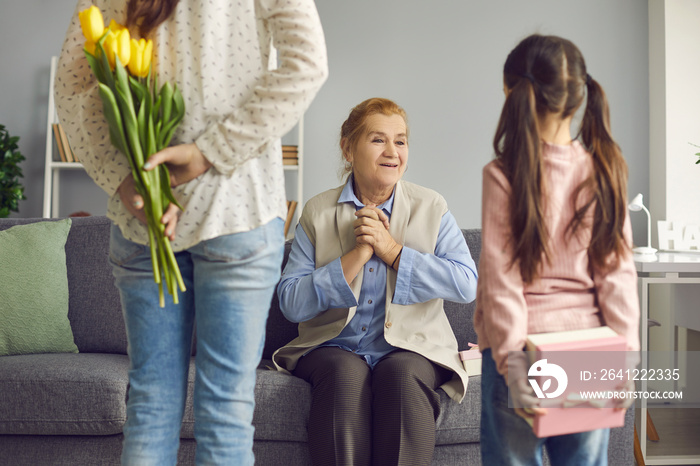 Pleasantly surprised older woman is happy that her daughter and granddaughter are going to congratul