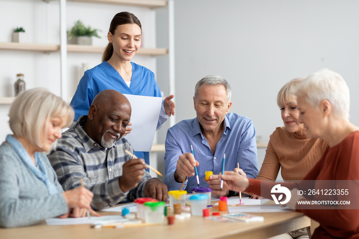 Happy elderly men and women doing arts and crafts together