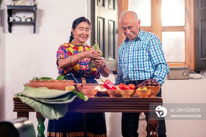 Retrato de adultos mayores cocinando tamales, un platillo tradicional Guatemalteco.