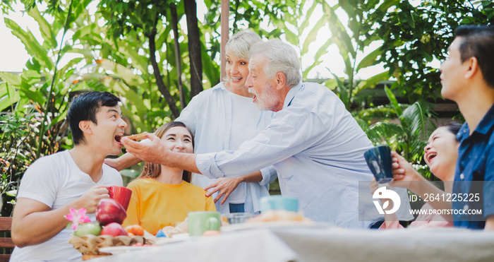 Mix aged big family enjoy having outdoor party eating food at backyard home, warm and happy lifestyl