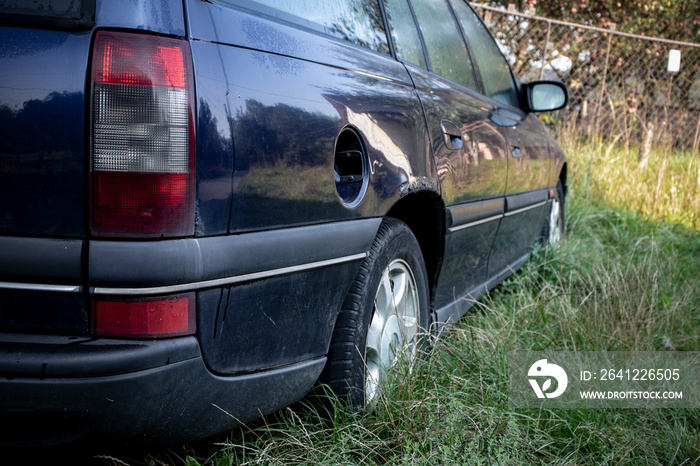 Rear view of an abandoned dark blue station wagon car