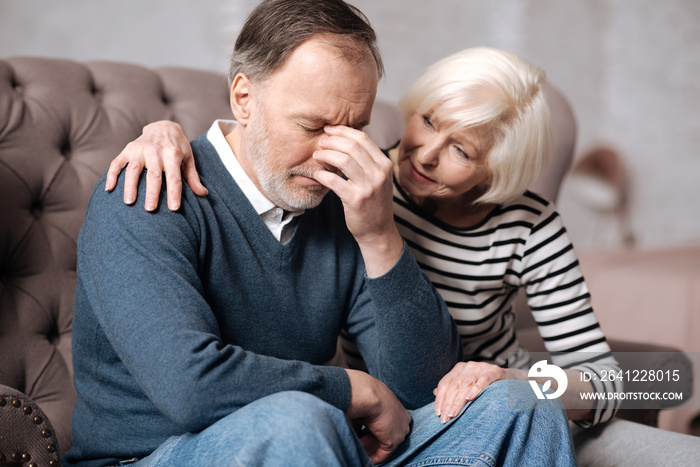 Aged woman calming down her depressed husband