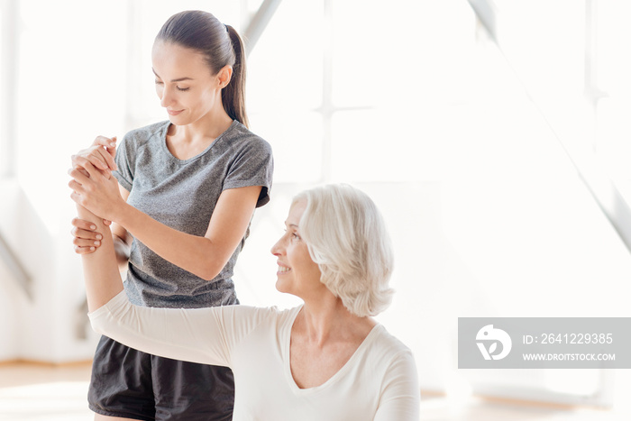 Attractive professional coach helping the elderly woman