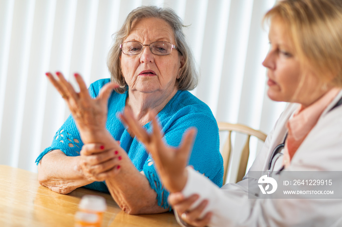 Female Doctor Talking with Senior Adult Woman About Hand Therapy