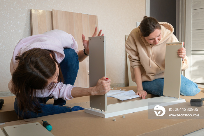 Woman reading instructions to assemble furniture. Self assembling furniture at home