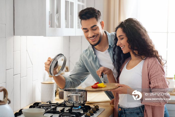 Portrait Of Happy Young Arab Couple Cooking Healthy Food In Kitchen Together