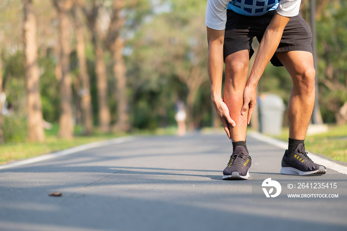 Young fitness man holding his sports leg injury. muscle painful during training. Asian runner having