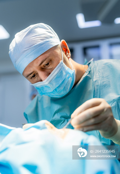 Surgeon performing complex surgery in the intensive care unit