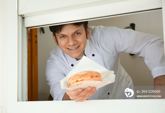 Pleasant seller offering snack from food truck cafe