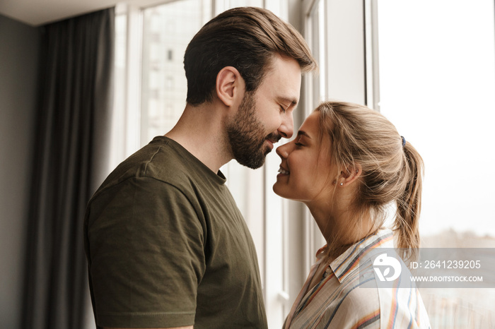 Photo of romantic cute couple smiling and hugging while standing