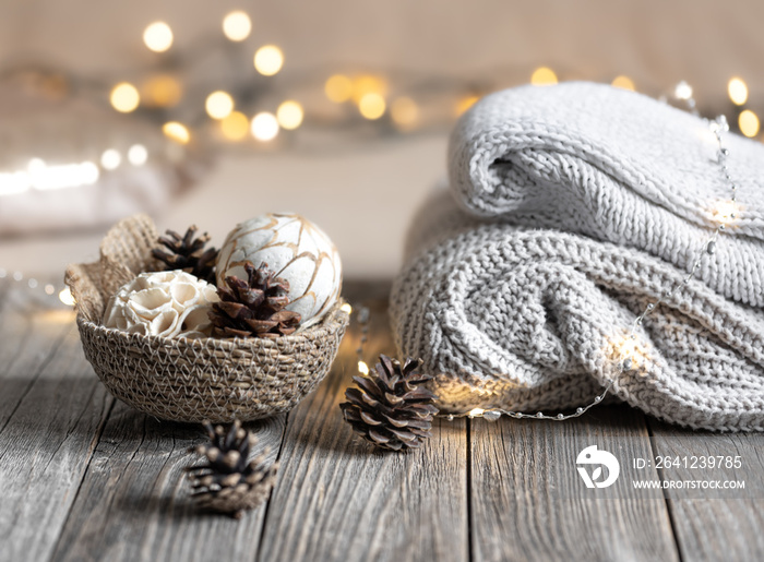 Cozy winter bokeh background with stacked sweaters and decor details.