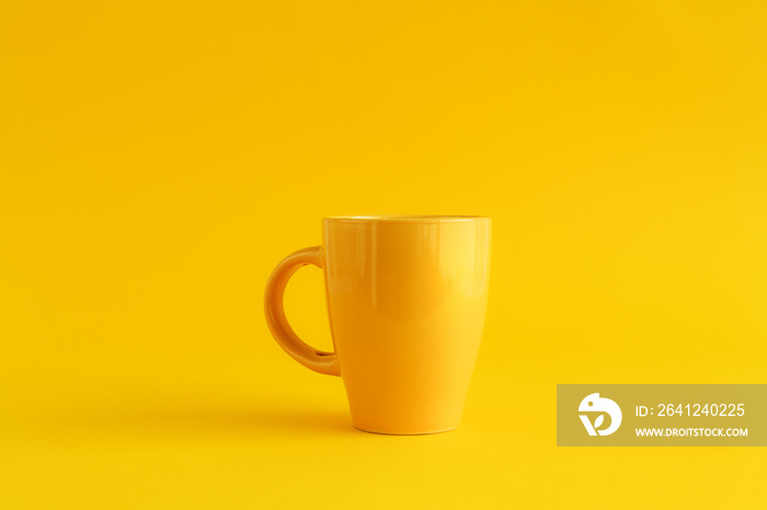 Single yellow coffee cup on yellow background