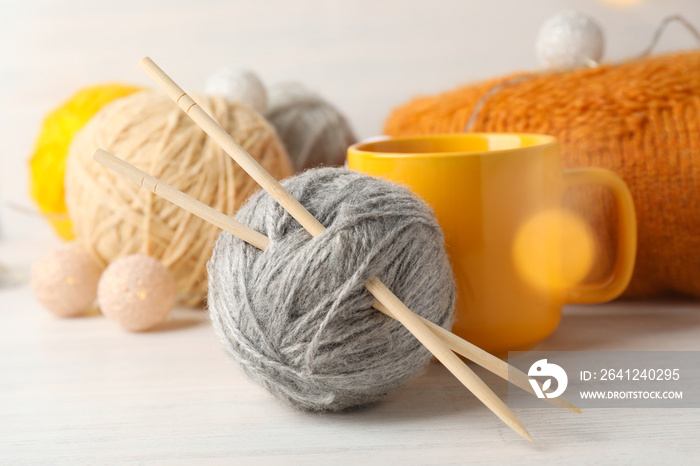 Concept of knitting with yarn balls on white wooden table, close up