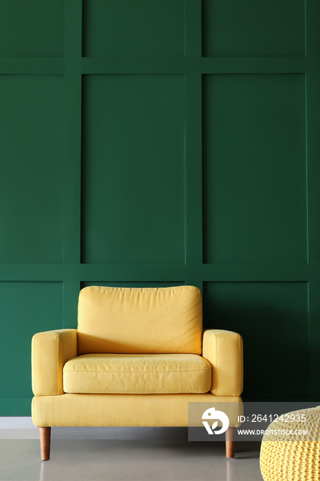 绿色墙壁附近舒适的黄色扶手椅和沙发