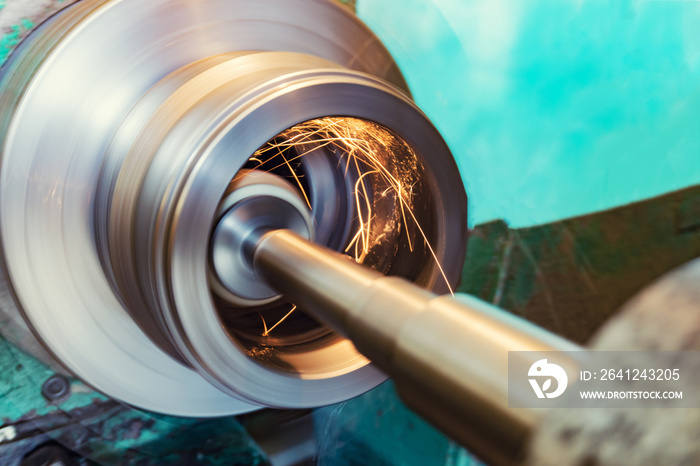 Internal grinding of a cylindrical part with an abrasive wheel on a machine, sparks fly in different