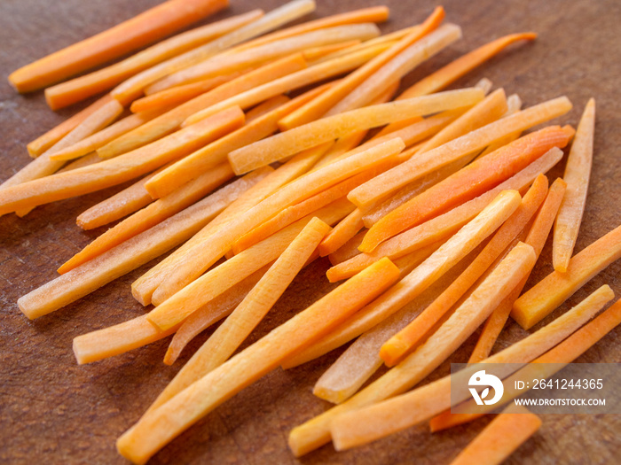 Side view of sliced ​​carrots. Closeup of julienne carrot on a wooden board.