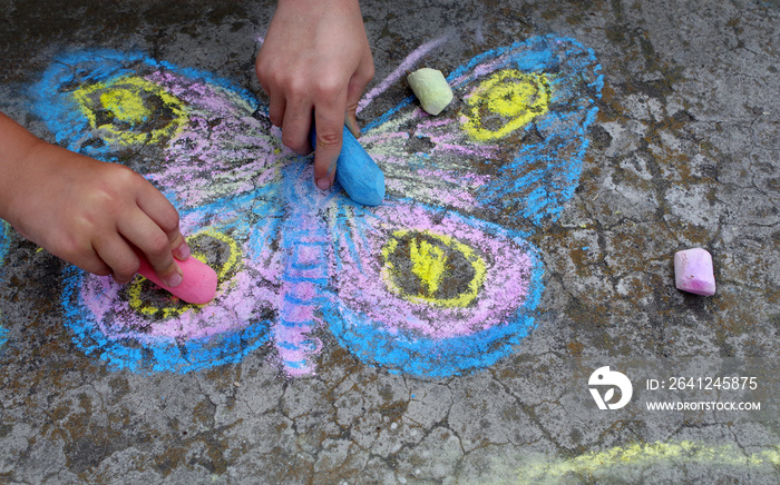 人行道上的儿童画。孩子们在人行道上用粉笔画蝴蝶。