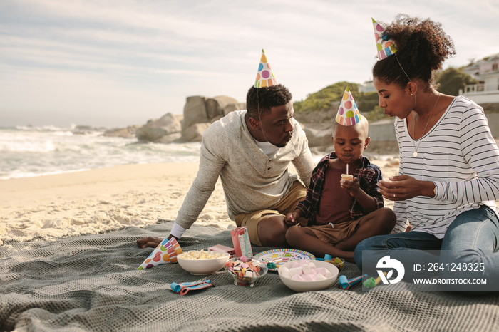 Family celebrating birthday of their son at the beach