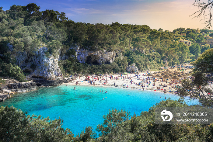 People on the beach enjoying the summer holiday on the coast of Mallorca island, in Cala Llombards i