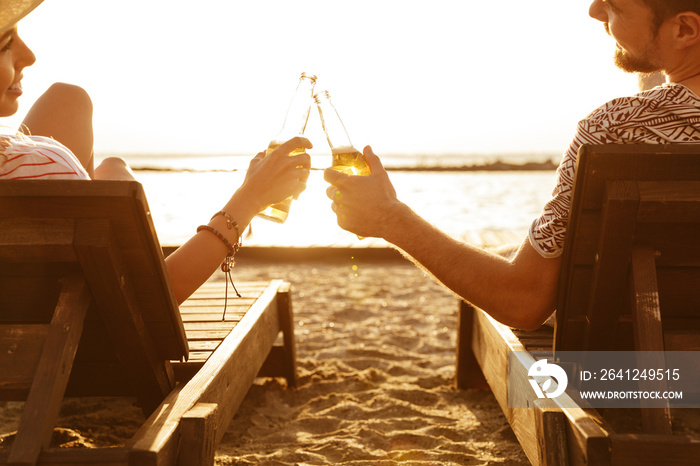 这对恩爱的情侣在户外海滩上喝啤酒休息。