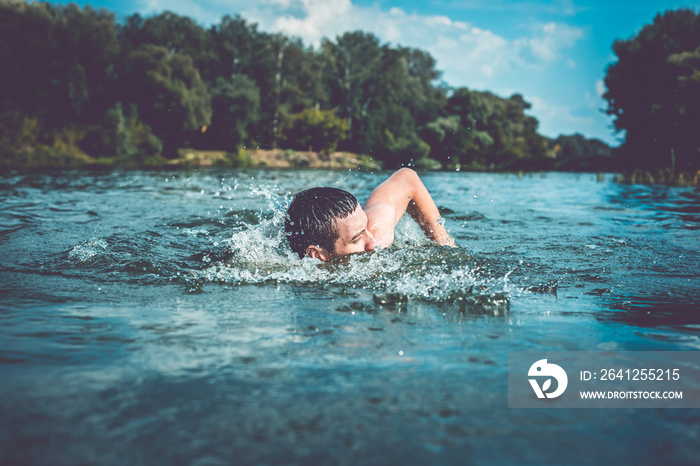 The young man swimming in the river