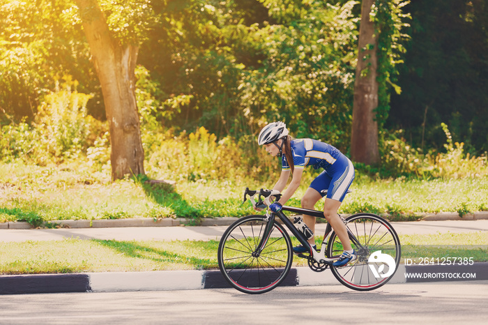 Female cyclist rides a racing bike on road