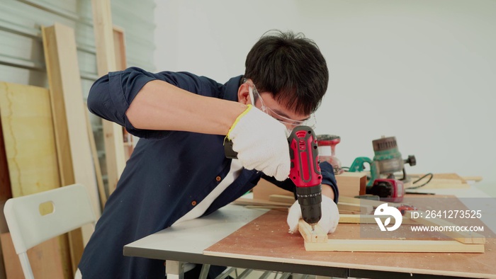 Asian woodworking technicians are using wood drills in factories, large workplaces.