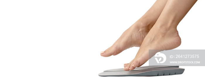 Beautiful female feets and insoles isolated on a white background. The girl tries on orthopedic inso