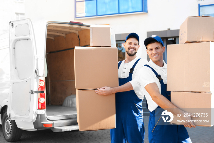 Delivery men with moving boxes near car